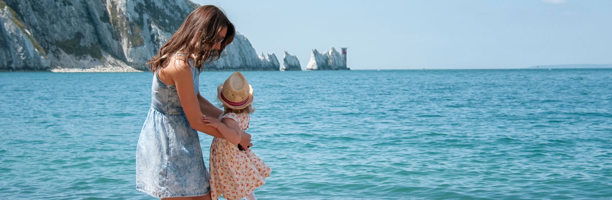 Mother and daughter on Alum Bay beaches with The Needles in background